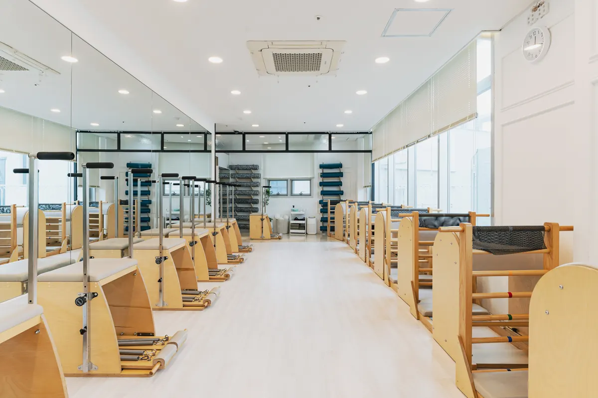 체어와 바렐 기구가 정렬된 발란스온 필라테스 그룹 수업실
